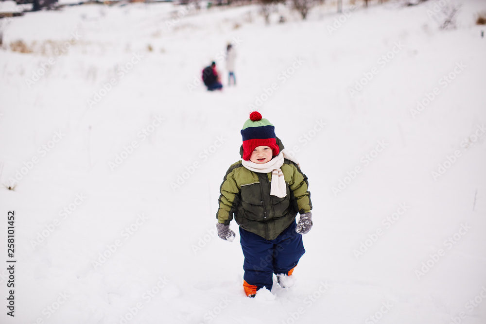 Little boy is running somewhere in the snow