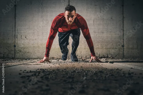 Obraz Zawodnik na niskim początku, rozpoczynający wyścig sprintu