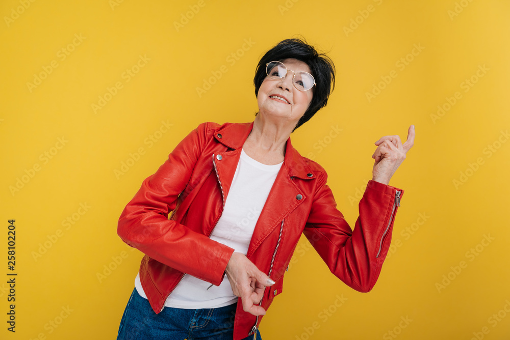 Low angle of smiling Caucasian elderly lady in fashionable clothes dancing indoors Low angle of smiling Caucasian elderly lady in fashionable clothes dancing indoors