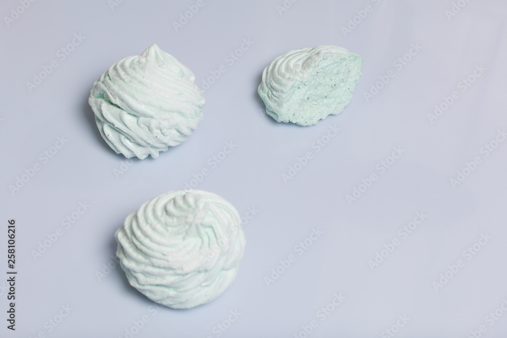 Homemade marshmallows laid on a white background. Marshmallow with mint, with a green tint. Nearby is a piece of marshmallow, its slice is visible. Homemade marshmallows laid on a white background. Marshmallow with mint, with a green tint. Nearby is a piece of marshmallow, its slice is visible.