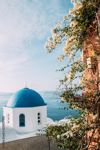 Sommer auf Santorini mit weisser Kirche und blauer Kuppel mit Meerblick in Griechenland