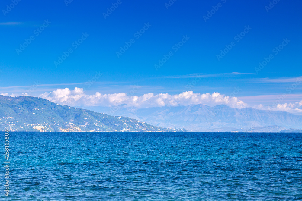 Wonderful romantic summertime seascape with crystal clear azure sea and coastline slopes.