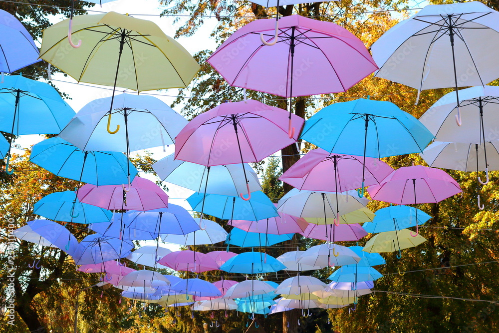 Colored umbrellas hang in the air as a protective roof against rain and sunshine