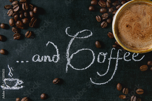 Cup of espresso coffee and coffee beans on vintage chalkboard with lettering as background. Flat lay, space.