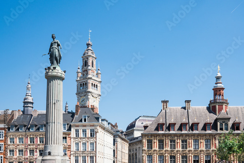 tower of Chamber of commerce, buildings at central town square in Lille, France. white sculpture,  against blue sky. space for text