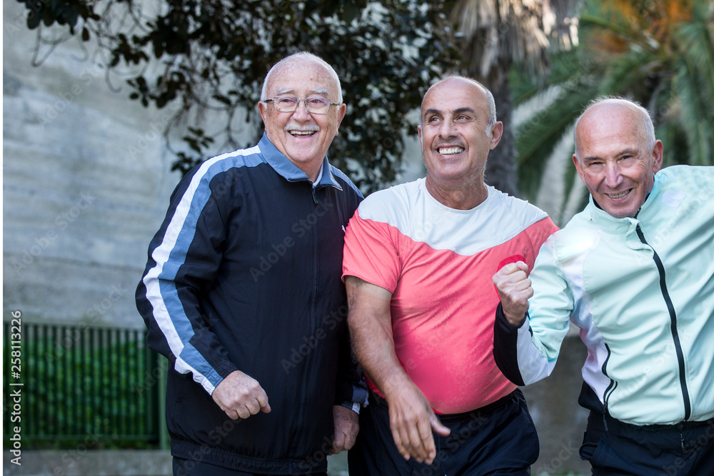 Gruppo di amici anziani festeggia e si diverte al parco in tuta da ginnastica Gruppo di amici anziani festeggia e si diverte al parco in tuta da ginnastica
