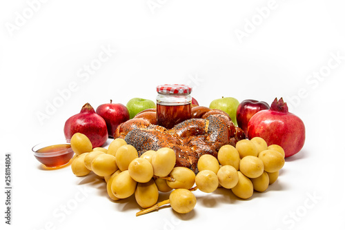 Fototapeta Naklejka Na Ścianę i Meble -  Rosh Hashanah (Jewish New Year) Traditional Symbols, Honey in a glass jar, Pomegranates, Dates, apples, Challah Bread. Isolated On A White Background