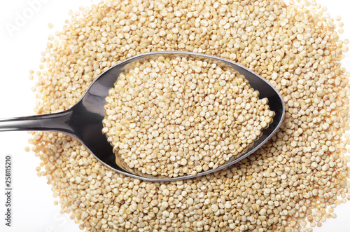 Raw organic superfood gluten free quinoa seeds in spoon closeup on white background