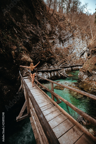 Woman walks over a wooden bridge in a gorge