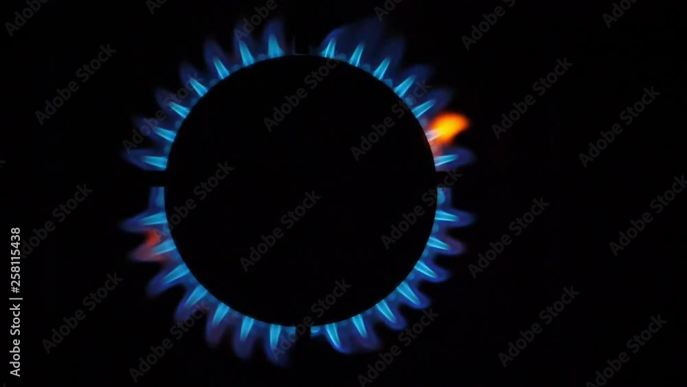 Kitchen burner flaming in the night, closeup. Top View