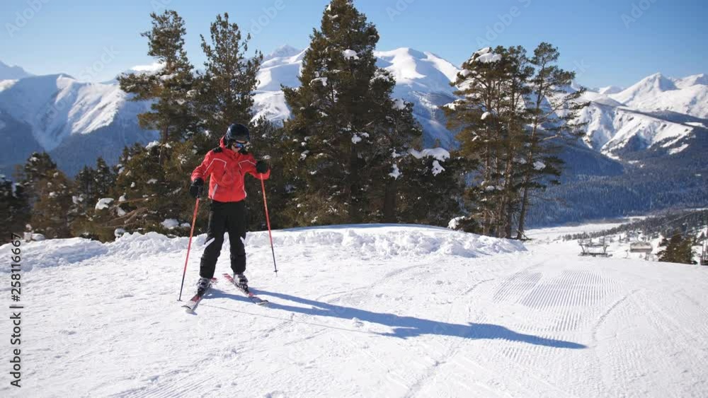 Couple skiing down empty ski slope on sunny winter day. A woman arrives on skis to male and the couple communicates. Couple skiing down empty ski slope on sunny winter day. A woman arrives on skis to male and the couple communicates.
