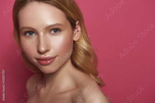 Gentle smiling blonde woman isolated on pink