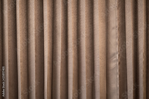 Curtain of brown color hanging and forming drapery