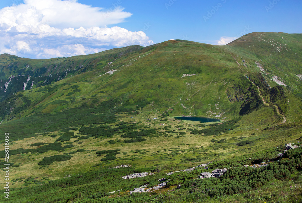Mountains with green vegetation and lake.