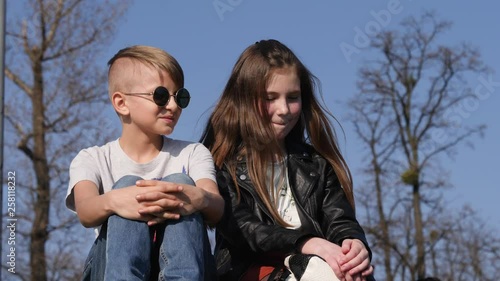 Boy and girl teenager friends sit together admiring a river water in Wroclaw Poalnd photo