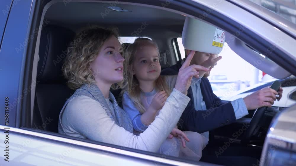family transport purchase, young customer family with child girl carefully consider auto interior sitting inside salon while buying new vehicle at car dealership family transport purchase, young customer family with child girl carefully consider auto interior sitting inside salon while buying new vehicle at car dealership
