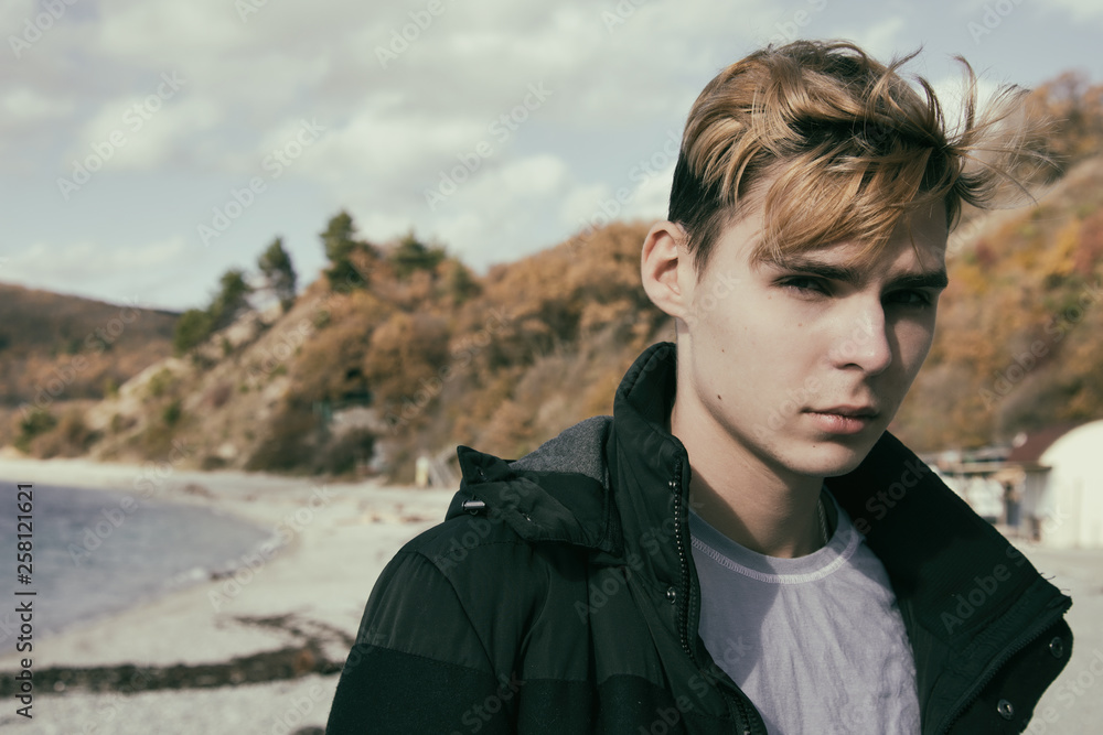 Cold weather. Young attractive guy is resting on the sea. Cold weather. Young attractive guy is resting on the sea.