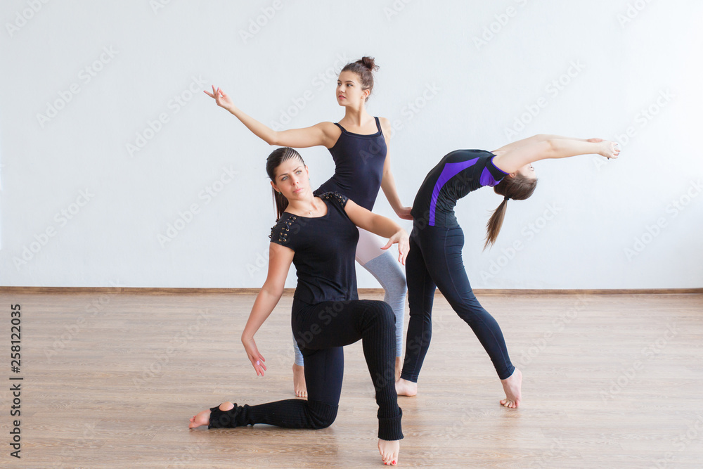 Fototapeta premium Three young dancer girls posing in a group composition.