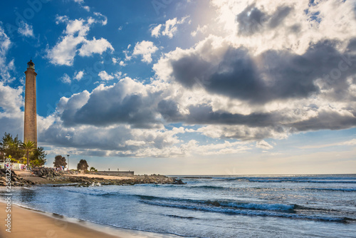 View of sea bay, sky with clouds and Maspalomas lighthouse at bright day. Gran Canaria, Spain