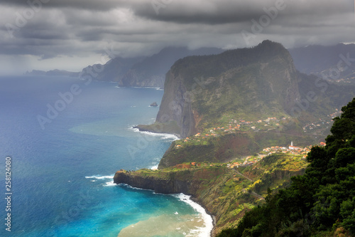 Beautiful view of the coastline of the island Madeira with vibrant green nature and blue ocean during a levada hike