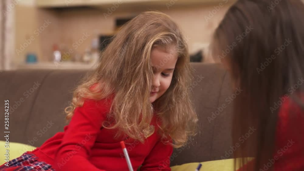 Charming little girls are drawing with colored pencils Charming little girls are drawing with colored pencils