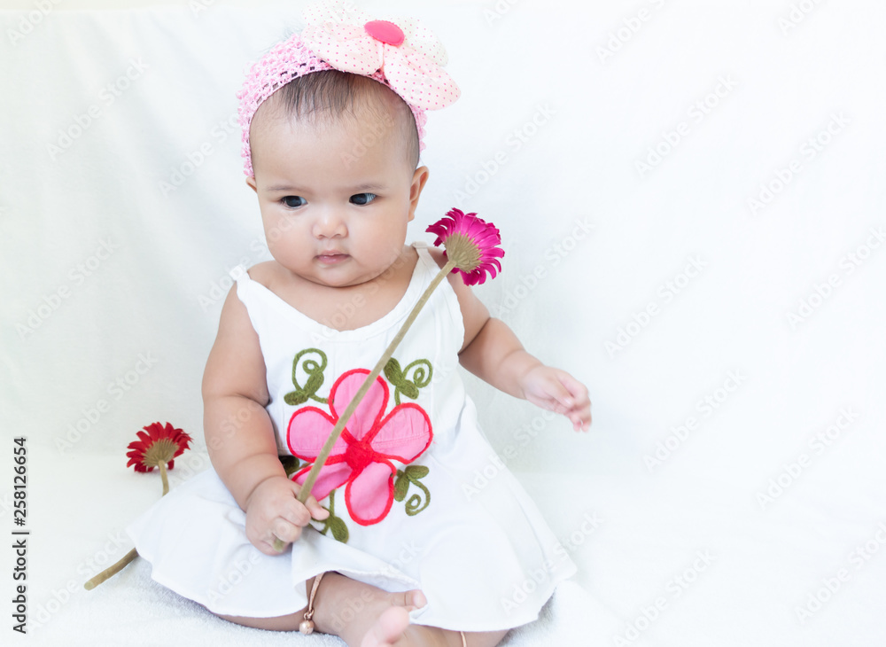 Baby girl holding pink and red flowers on white background Baby girl holding pink and red flowers on white background