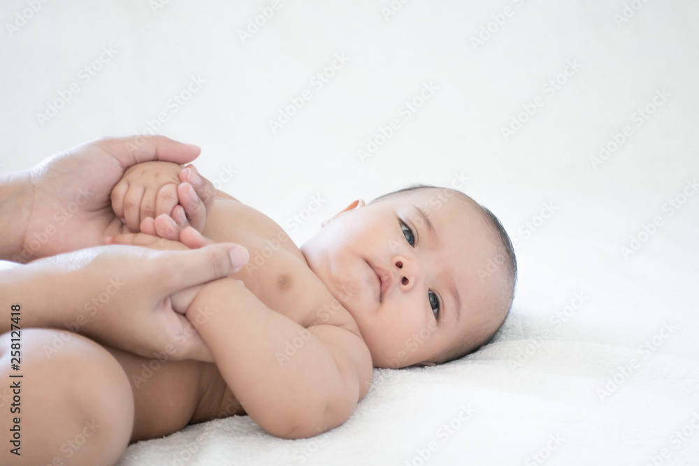 Mother hands touching baby with love and care, Asian baby girl after shower on the white background Mother hands touching baby with love and care, Asian baby girl after shower on the white background