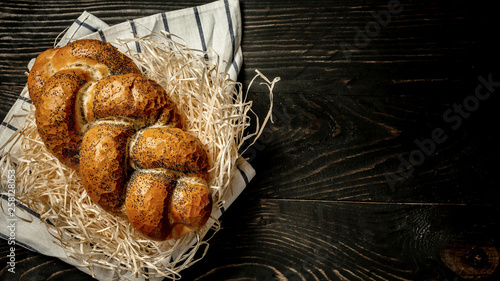Traditional jewish bread brown challah on wooden background. Rustic concept. Close up photo