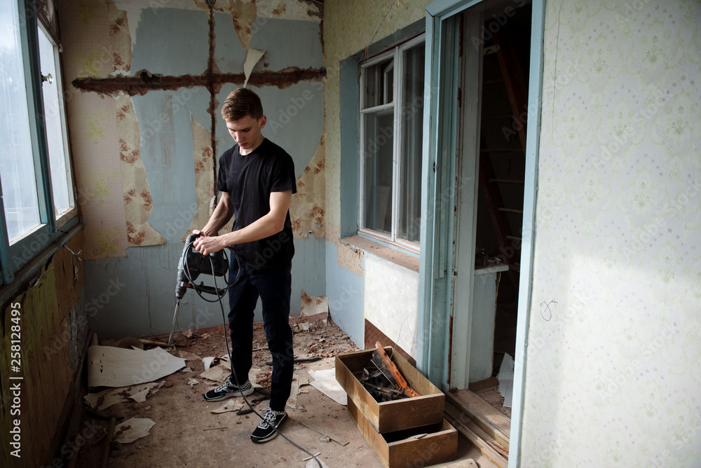Young man reels the cord from the tool. Young man reels the cord from the tool.