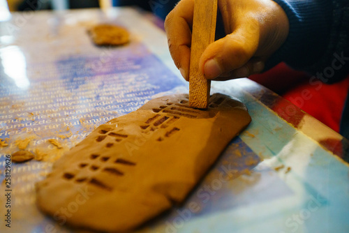 Children education sumerian clay tablet. Ancient type of Akkad empire style cuneiform writing in brown clay with tool. kids education. children education clay photo