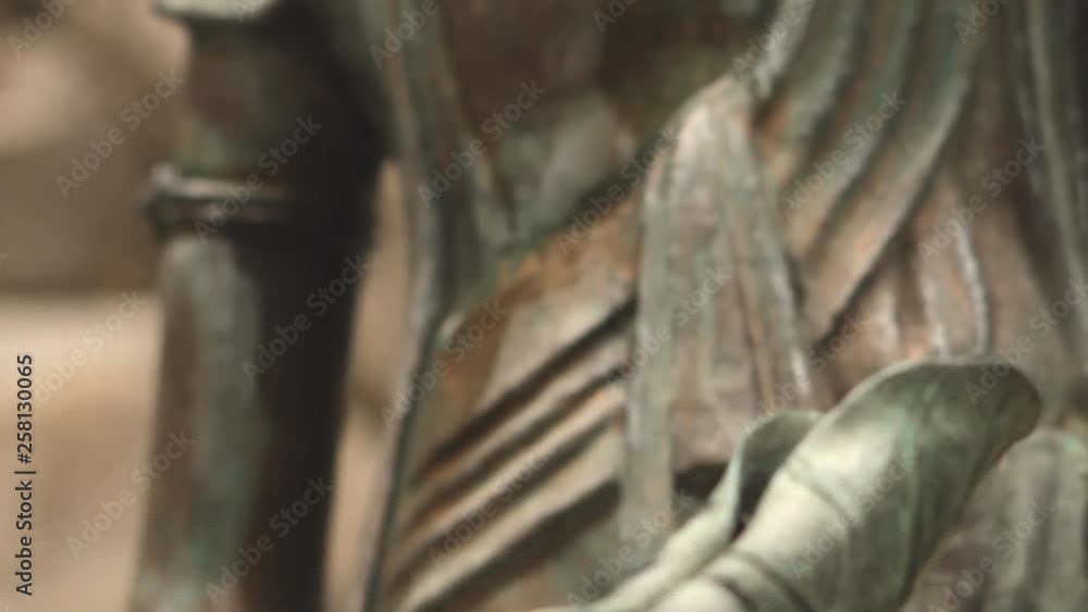 Selective focus close up on green fountain leaf flowing with water moving to focus panning up shot to Green copper ornate Buddha statue. Selective focus close up on green fountain leaf flowing with water moving to focus panning up shot to Green copper ornate Buddha statue.
