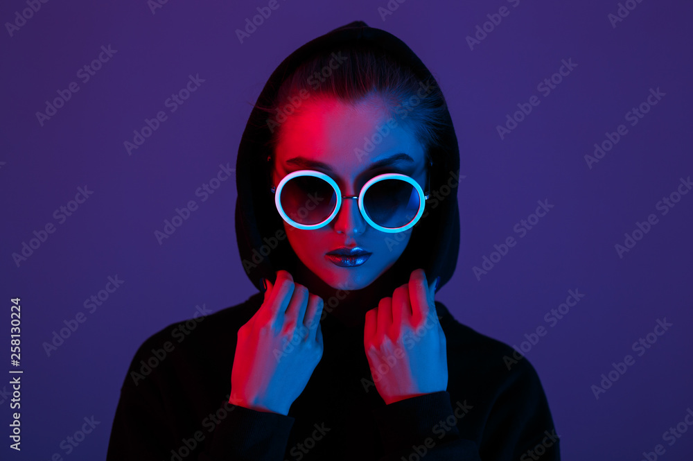 Φωτογραφία Portrait of fashion young girl in a black sweater with a hood and round sunglass