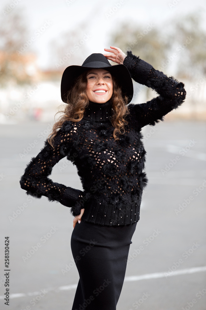 Charming stylish brunette girl dressed in a stylish knitted black