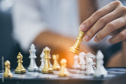 hand of businesswoman moving chess figure in competition success play. strategy, management or leadership concept.