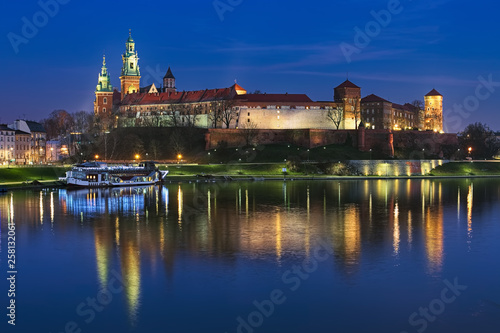 Krakow, Poland. Wawel Hill with Wawel Royal Castle and Wawel Cathedral in twilight. View from Debnicki bridge across Vistula river.