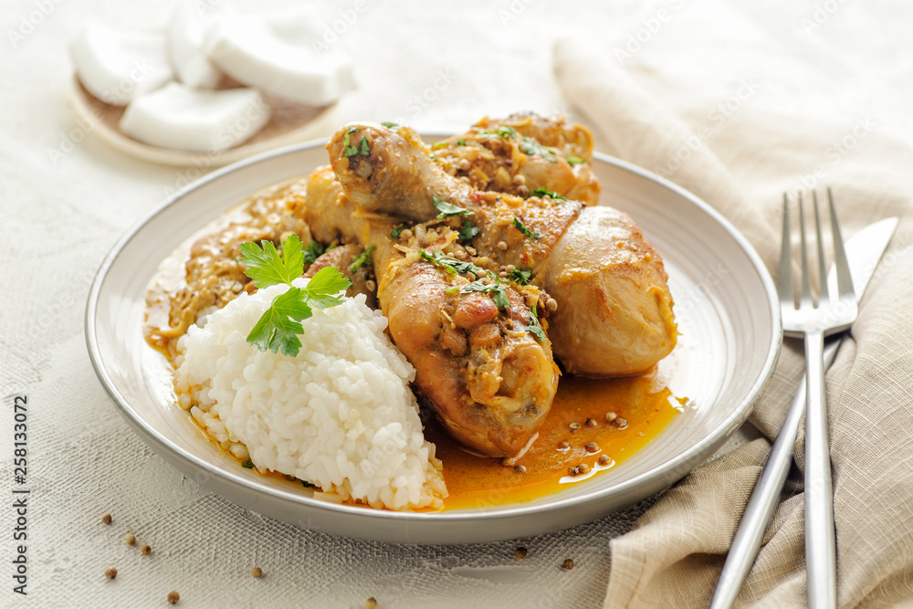 Chicken legs braised in curry and coconut sauce. With rice for garnish. Chicken legs braised in curry and coconut sauce. With rice for garnish.