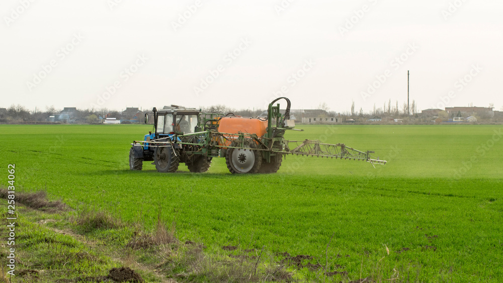 Tractor with a spray device for finely dispersed fertilizer.