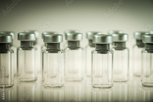 Vaccine glass bottles on grey background