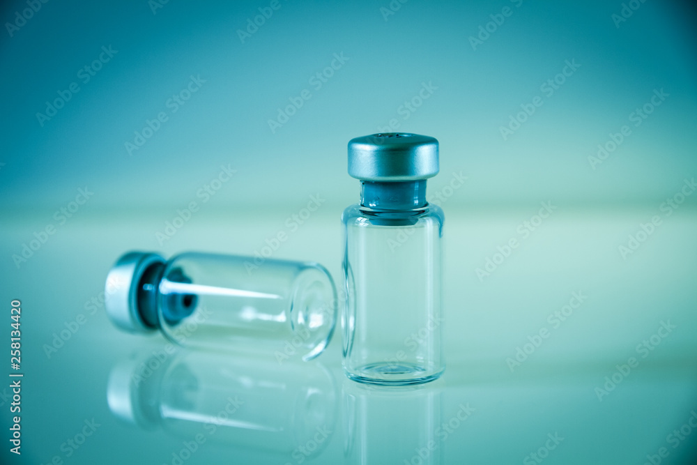 two vaccine bottles on blue background two vaccine bottles on blue background