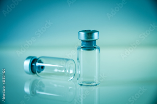 two vaccine bottles on blue background