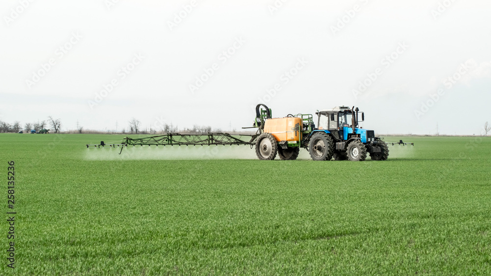 Obraz premium Tractor with a spray device for finely dispersed fertilizer.