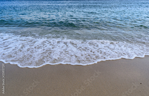Atlantic Ocean - Blue sea with wave foam spreading in the sand after busting