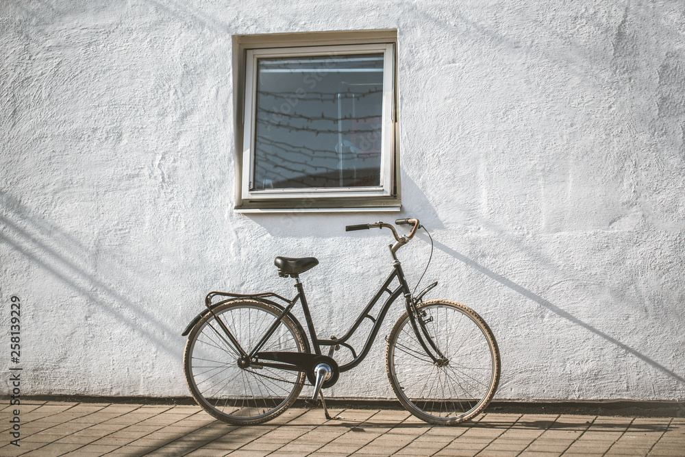 Retro bicycle on roadside with vintage concrete wall background
