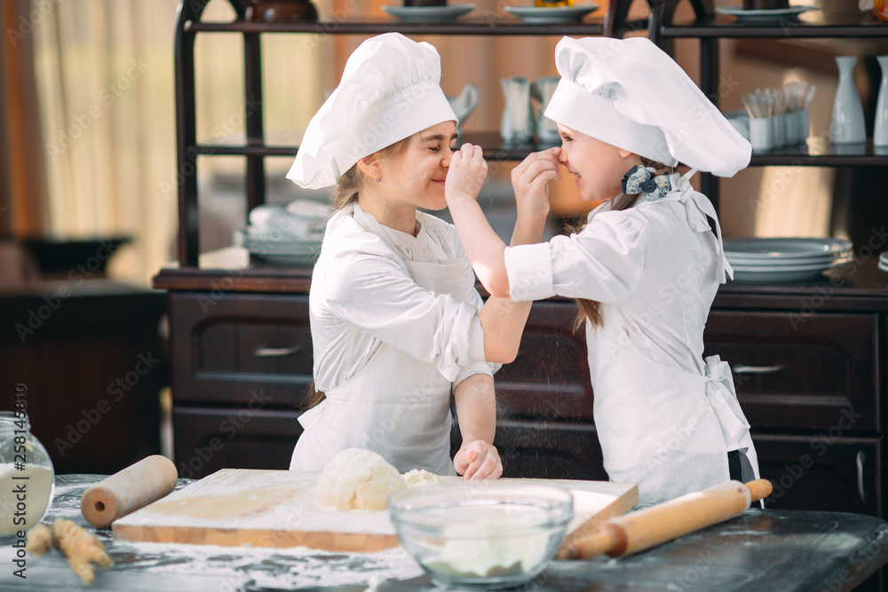 funny girls kids are preparing the dough in the kitchen. funny girls kids are preparing the dough in the kitchen.