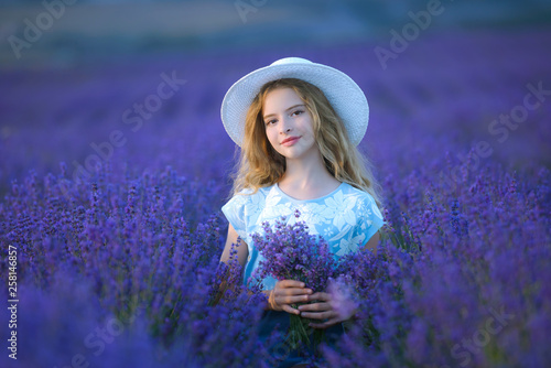 Beautiful girl on the lavender field on sunset. Soft focus