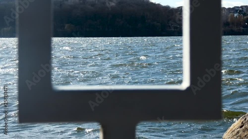 View of the evening city pond through the fence