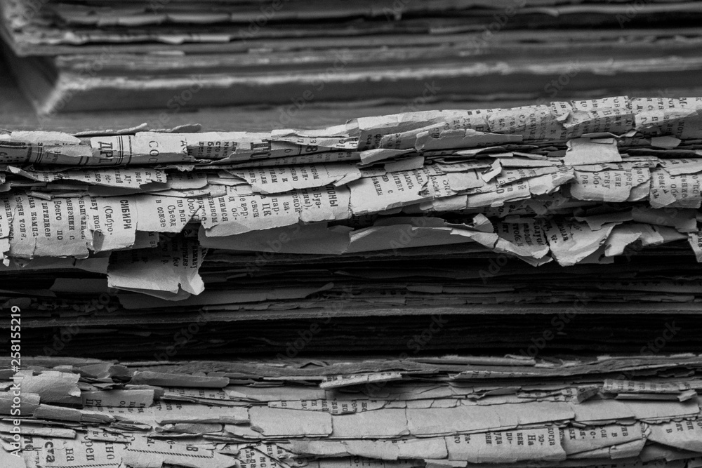 Stack of old papers on wooden shelf, paper texture, vintage black and white monochrome background