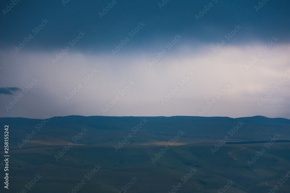 Overcast clouds in the distance over the hills