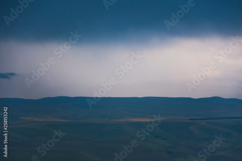 Overcast clouds in the distance over the hills