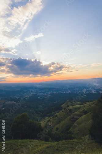 Sunset over Kislovodsk from a height in summer, the rays of the sun through the clouds. © dmitriydanilov62